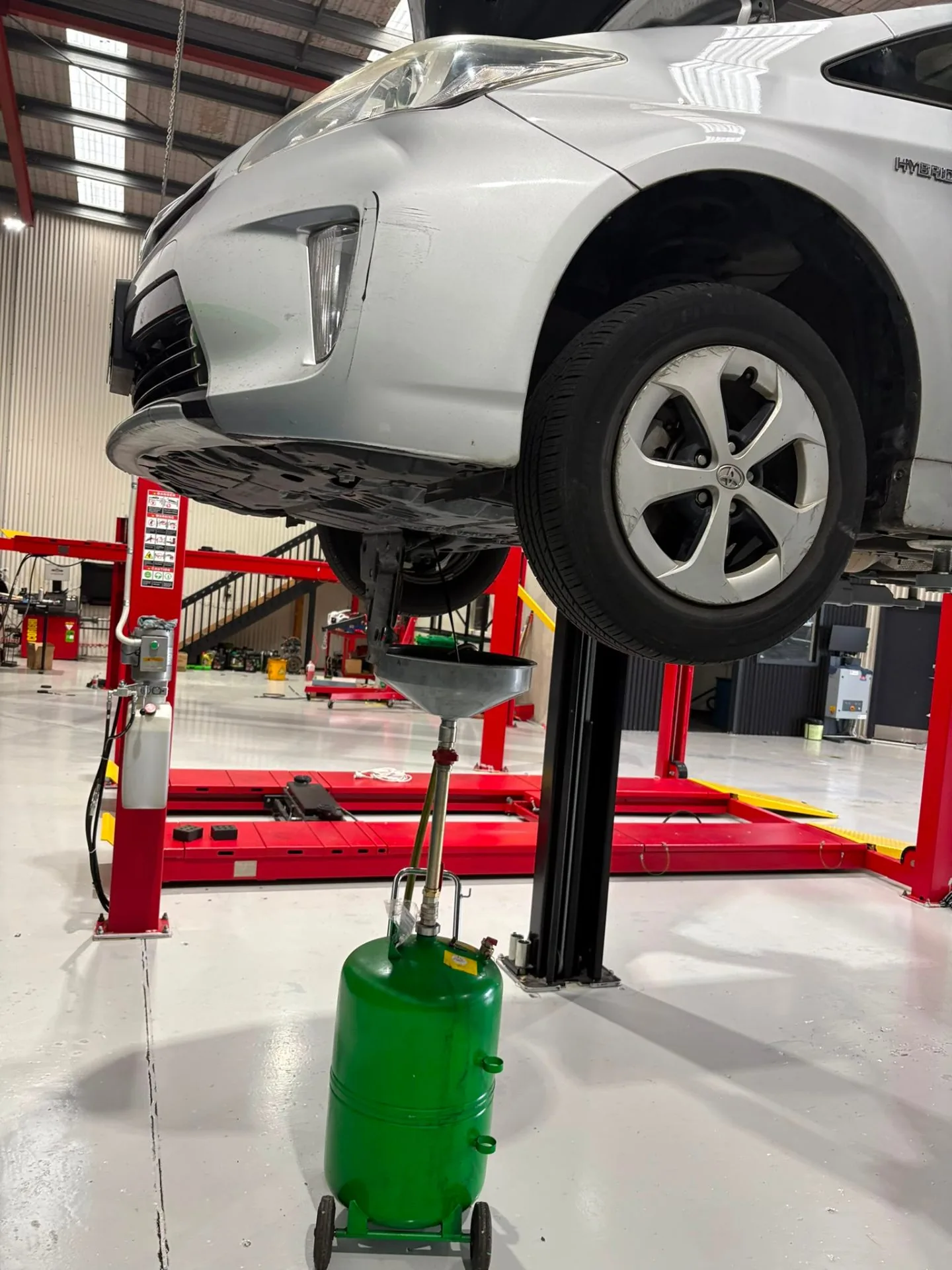 Prius on two-post lift with oil drain in position