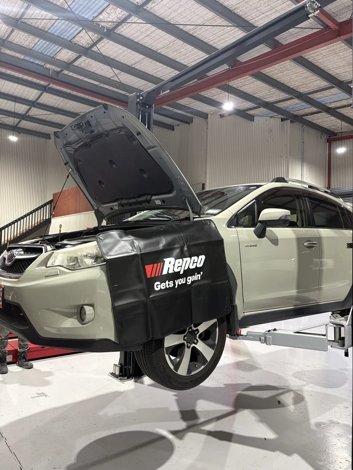 Toyota hybrid SUV raised on the two-post hoist for inspection