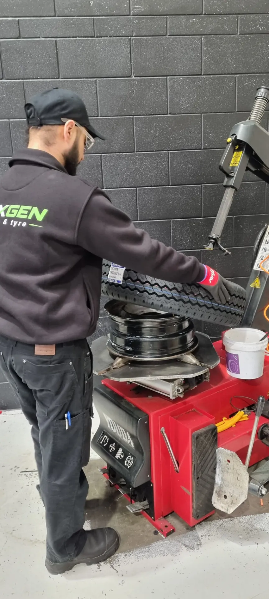 Fitting a new tyre onto an alloy rim on the Youda tyre changer